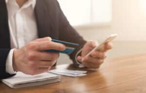 Man paying bills with electronic bill presentment and payment app on mobile phone.