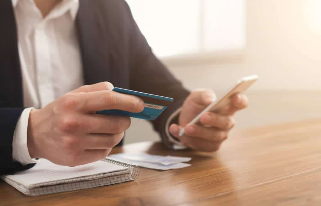 Man paying bills with electronic bill presentment and payment app on mobile phone.