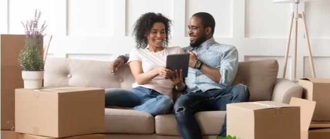 Millennial Mortgage Holders reading their statement on a tablet while sitting on the couch.