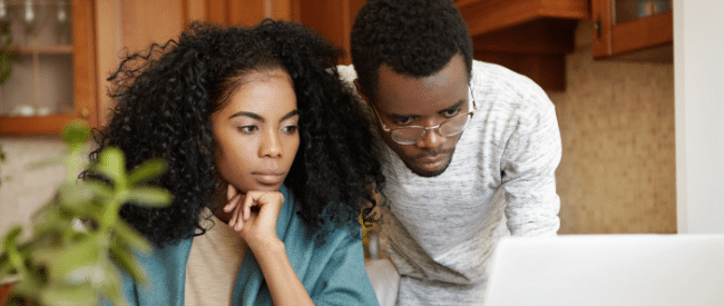 African American couple looking at medical bills on laptop