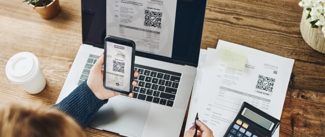 smartphone scans QR on paper blling statement and on laptop computer